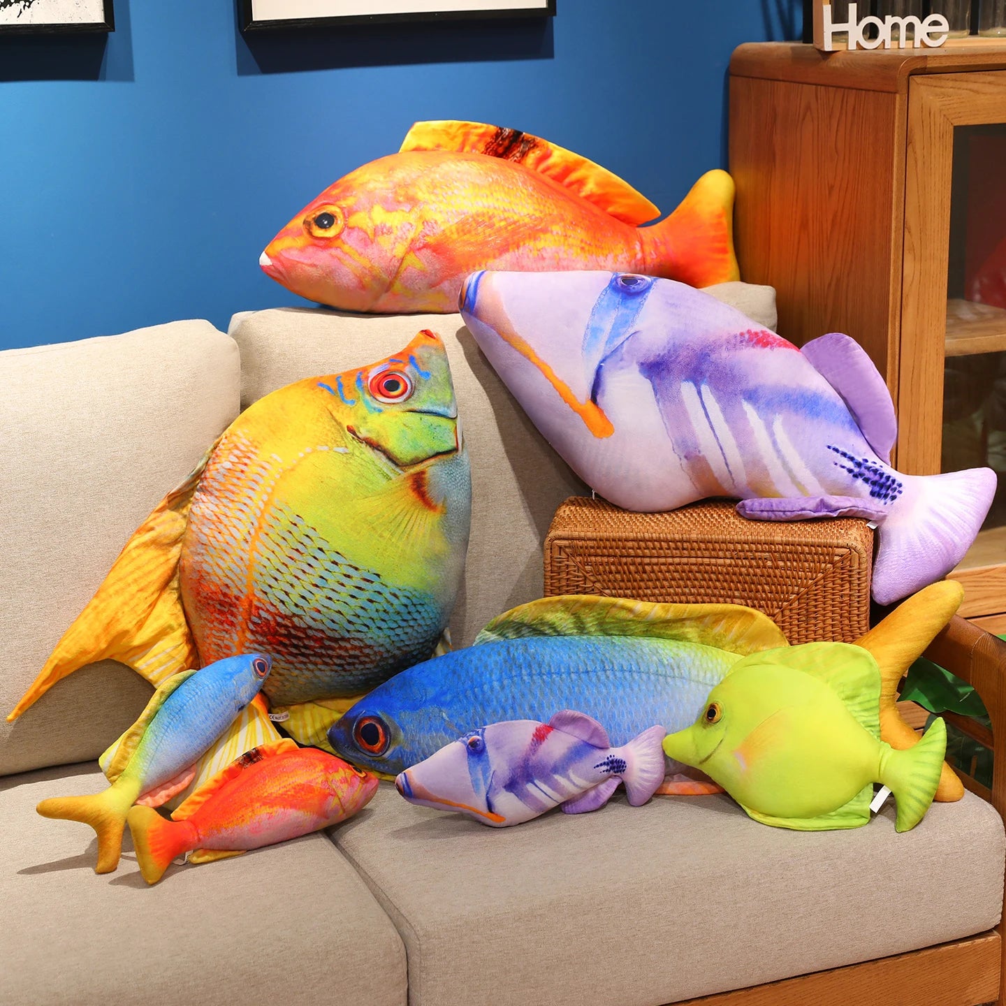 Colourful fish soft toy set in blue, green, orange and purple, arranged together on a couch