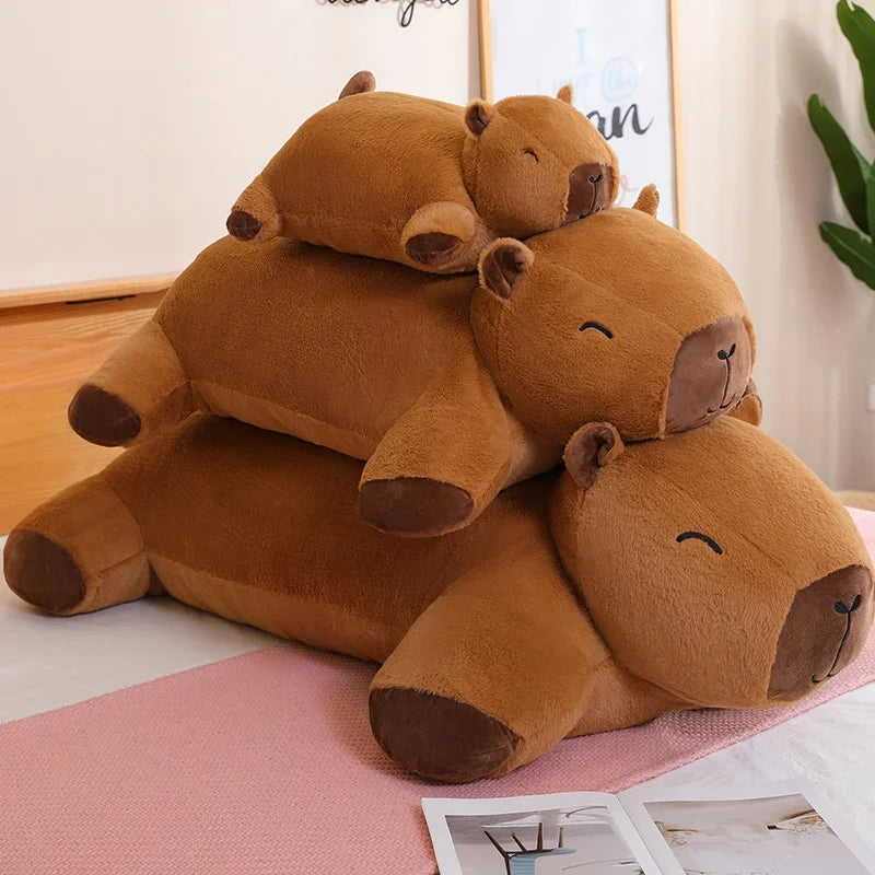 Stack of brown plush capybara toys on a pink surface with a light background