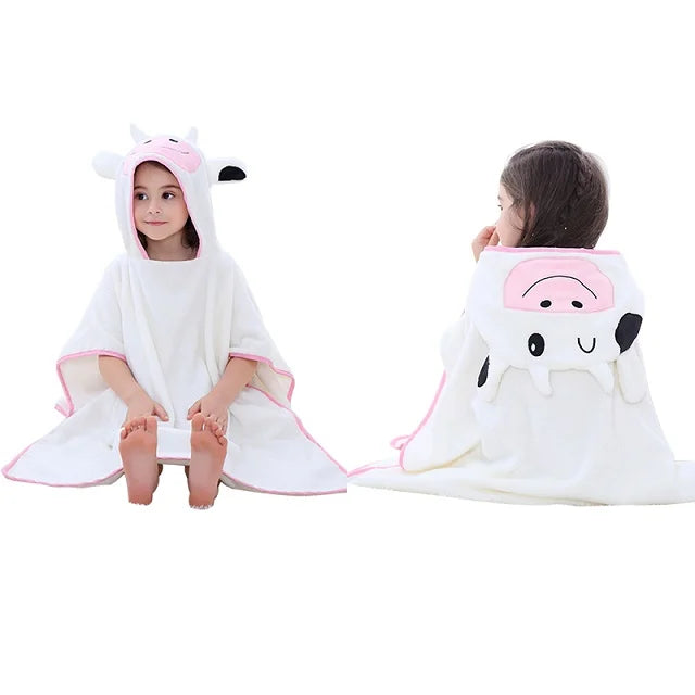 Two children wearing white hooded ponchos with a cow face hood on a white background