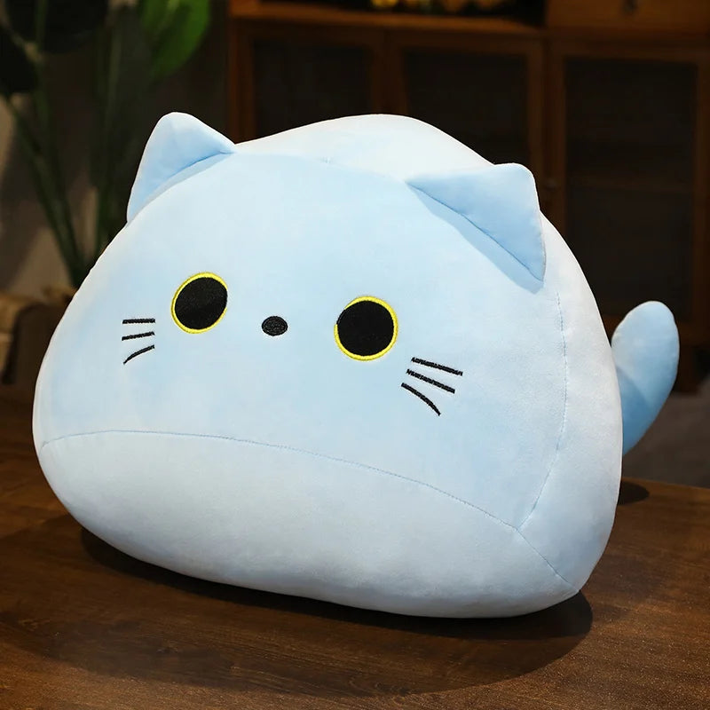Blue soft plush cat toy on a wooden surface with a burred background.