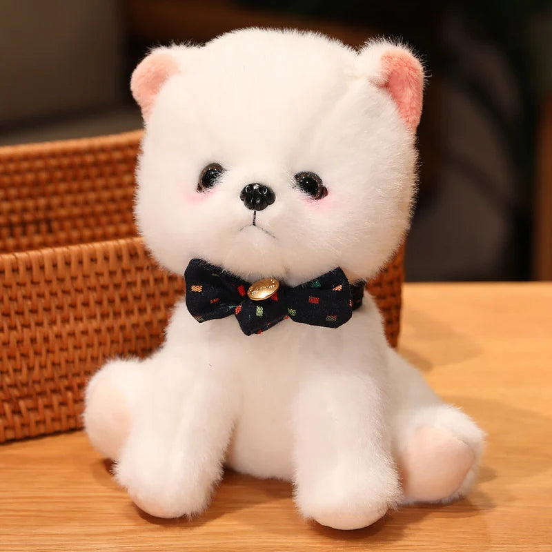 White plush toy with a black bow tie on a wooden surface