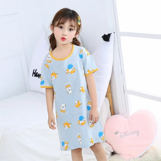 Child wearing a light blue nightie with cartoon corgi dogs on a white background