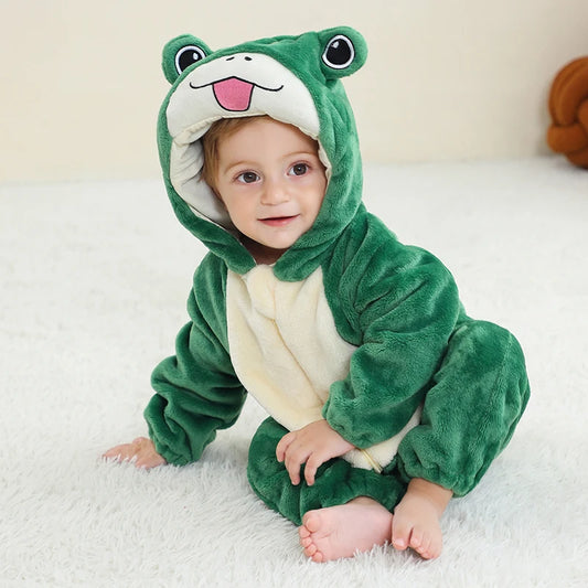 Child wearing a green frog onesie on a white fluffy surface