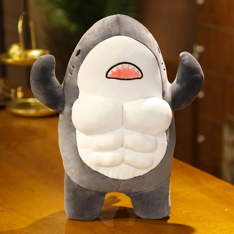 Grey soft plush muscular shark toy standing on a wooden surface.
