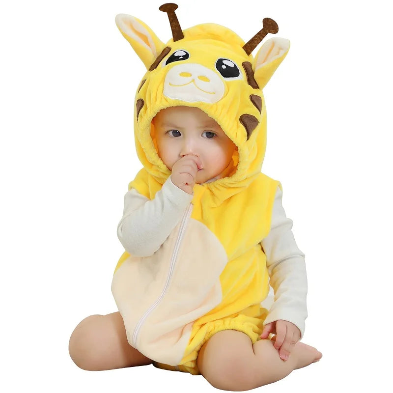 Baby wearing a giraffe hooded onesie on a white surface. 