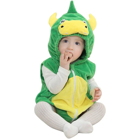 Baby wearing a dinosaur hooded onesie on a white surface. 