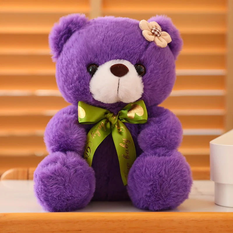 Purple soft plush teddy bear sitting on a wooden surface