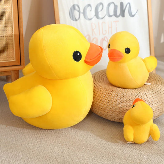 Yellow duck plush toy set with large and small duck plushies, displayed beside a woven stand in a room setting