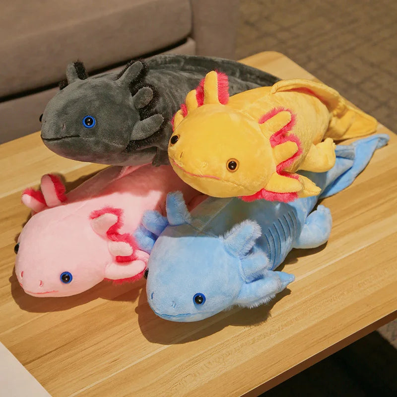 Four plush axolotls in different colours on a wooden surface.