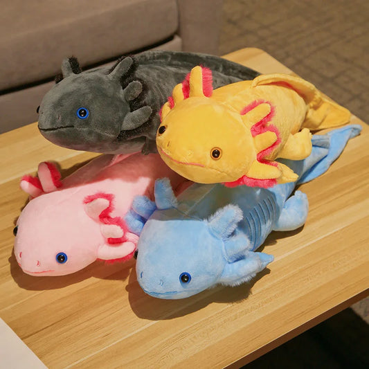Four plush axolotls in different colours on a wooden surface.