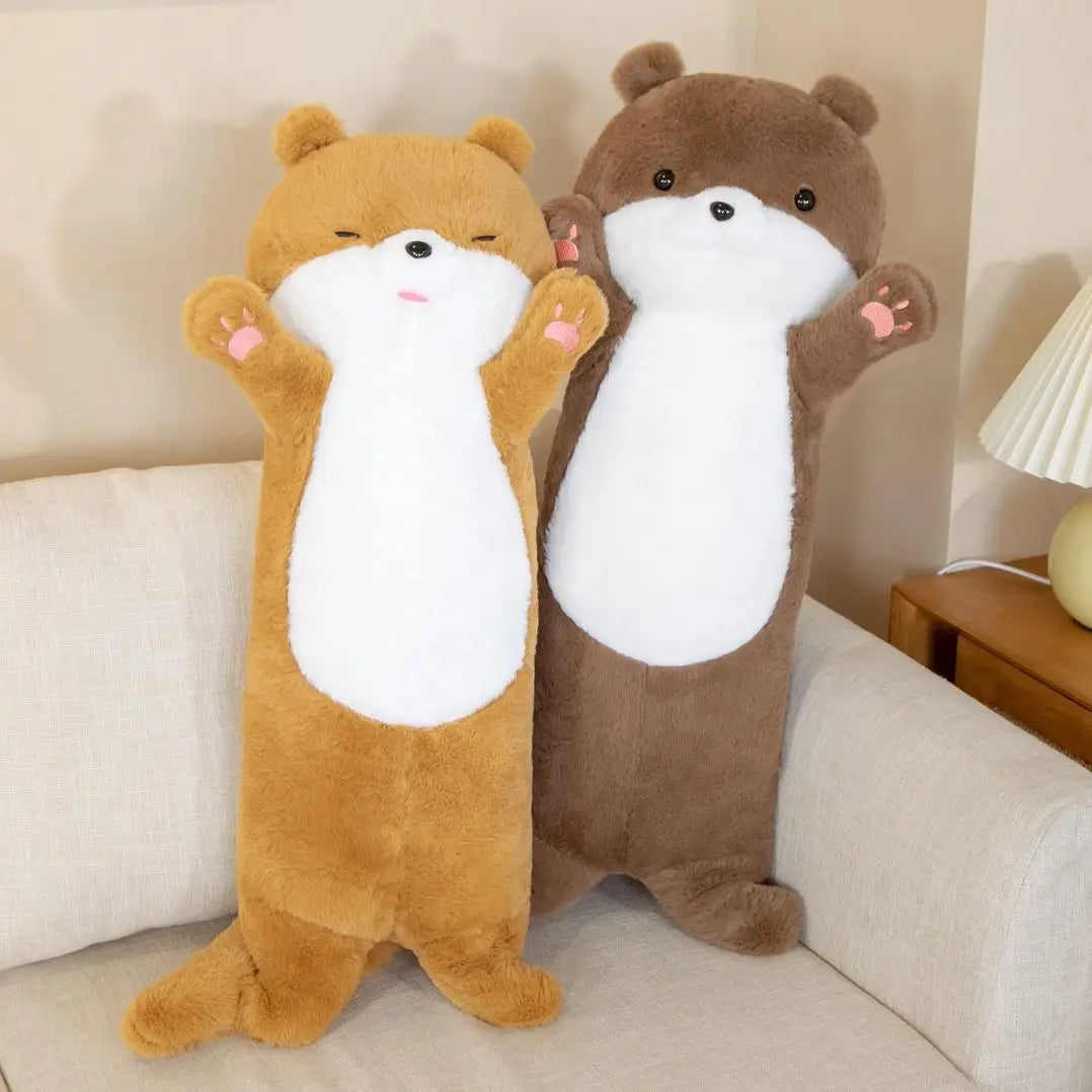 Two plush animal toys resembling otters on a couch.
