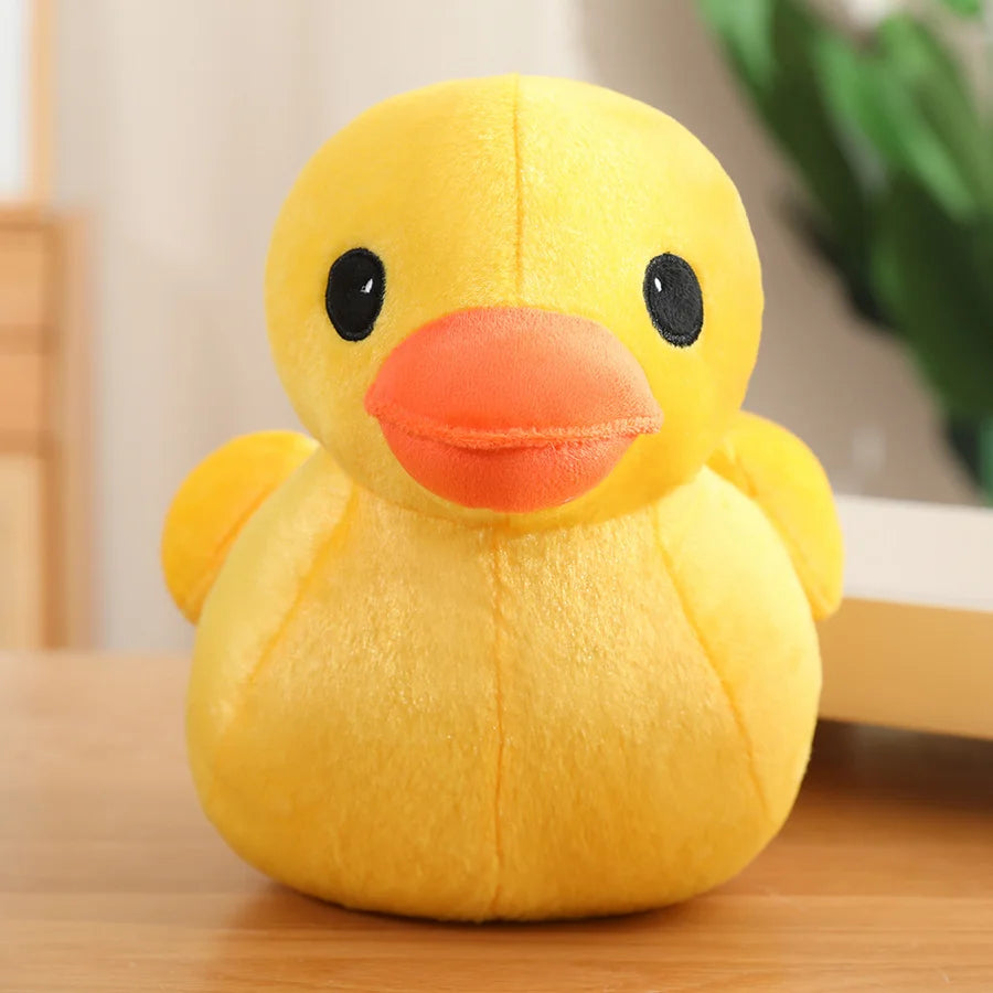 Yellow duck plush toy with an orange beak and black eyes, shown from the front with a soft plush finish