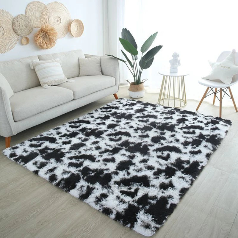 Black and white cow print rectangular plush rug placed on the floor in a bright living room