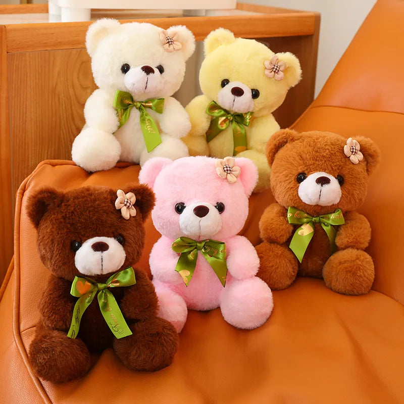 Multiple coloured soft cute teddy bears sitting on a couch.
