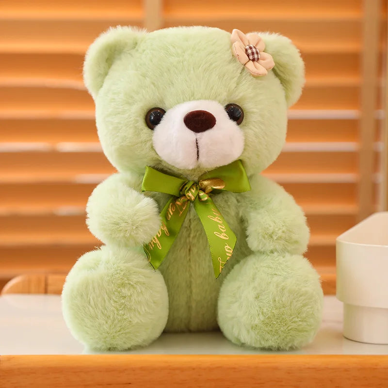 Green soft plush teddy bear sitting on a wooden surface