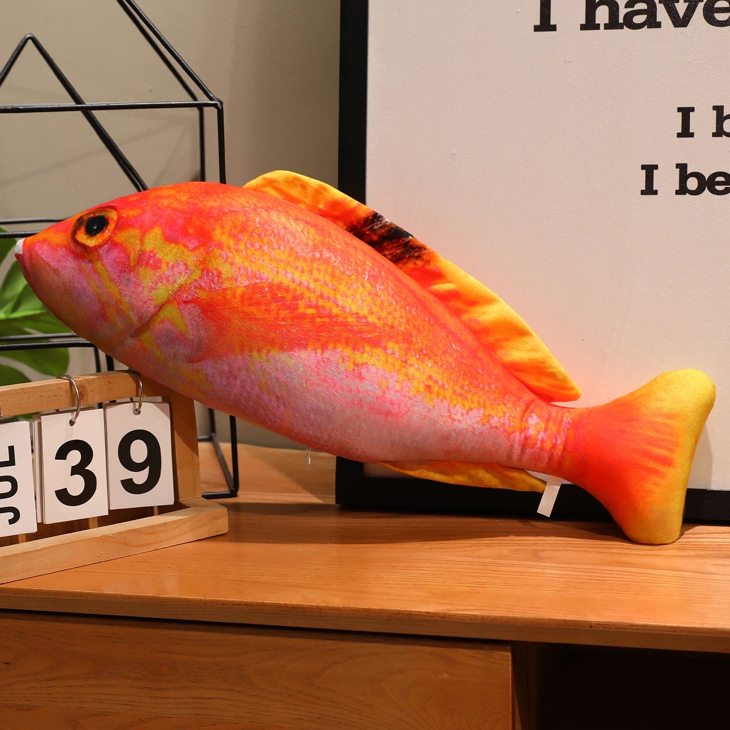 Orange and pink fish soft toy with a realistic printed scale pattern