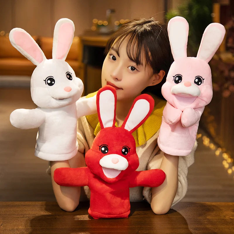 Person holding three colourful rabbit-shaped hand puppets in a home setting.