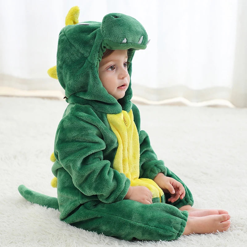 Child wearing a green dinosaur onesie on a white background