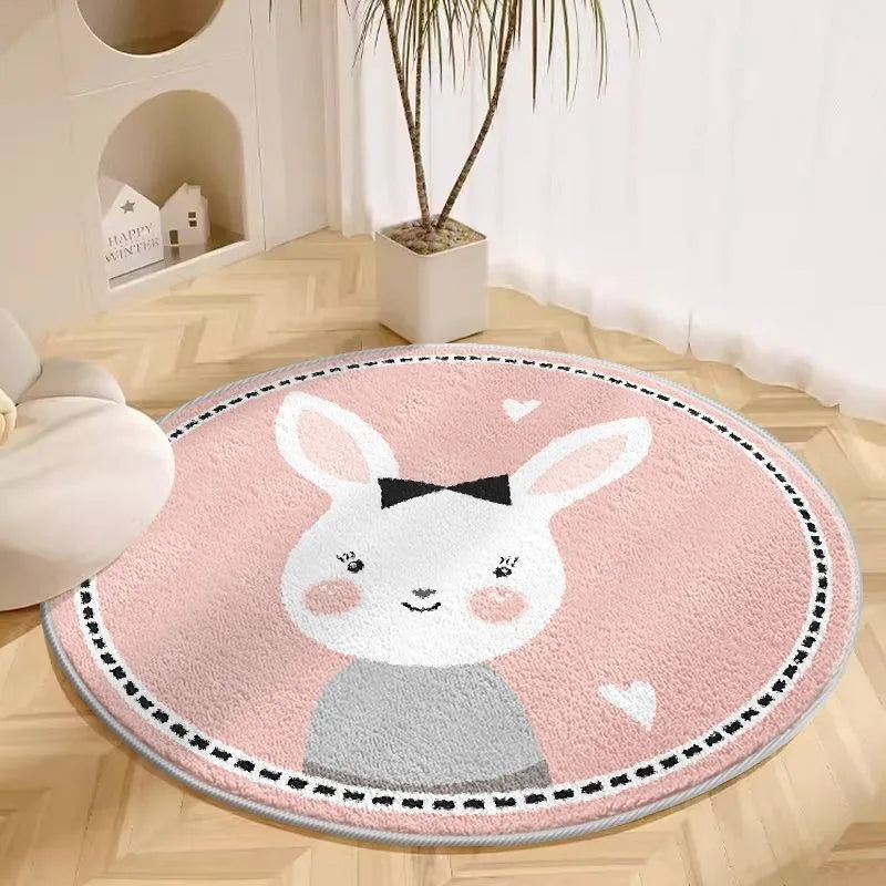 Pink round cartoon rug with white bunny face design placed on a light floor in a nursery setting