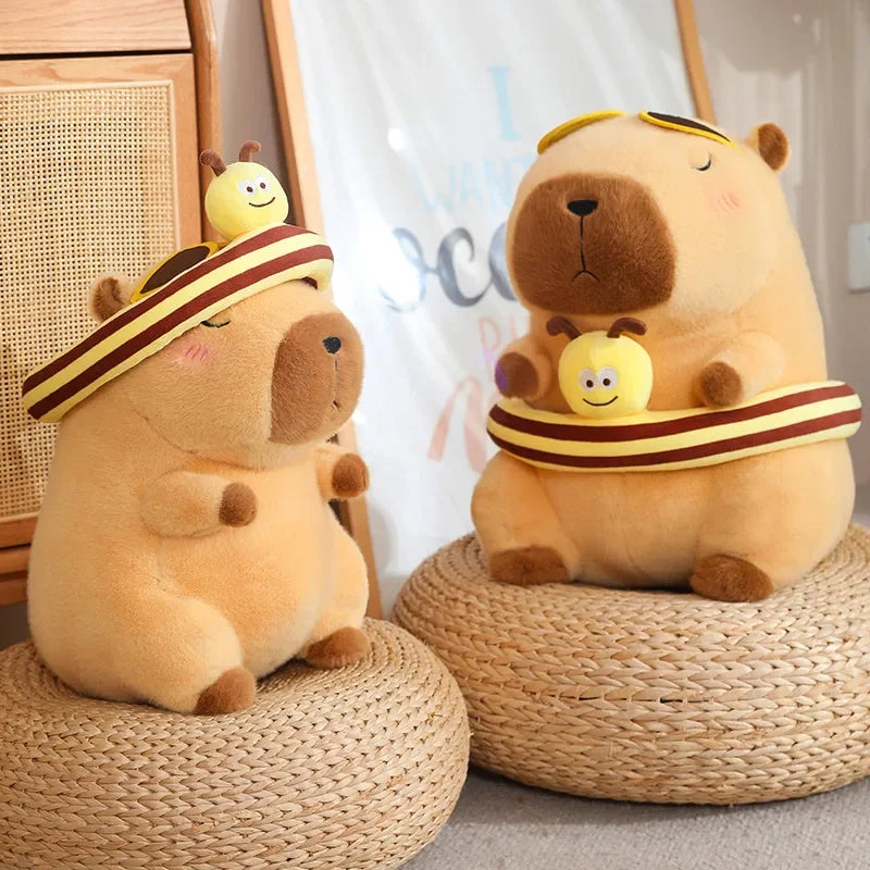 Two Capybara plush toys with a bumble bee band.