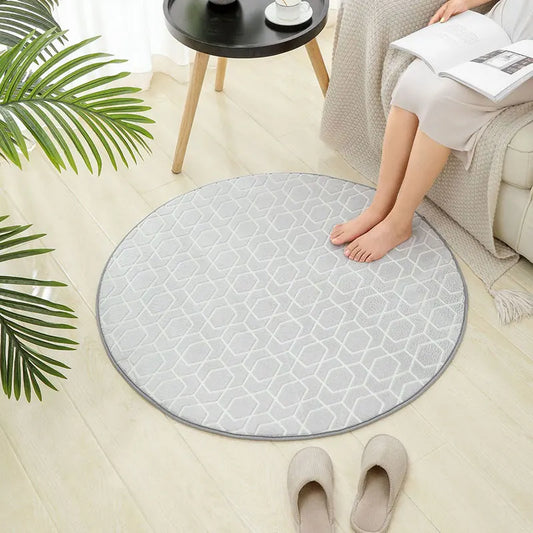 Round grey geometric print kids rug placed on a light wood floor beside a sofa