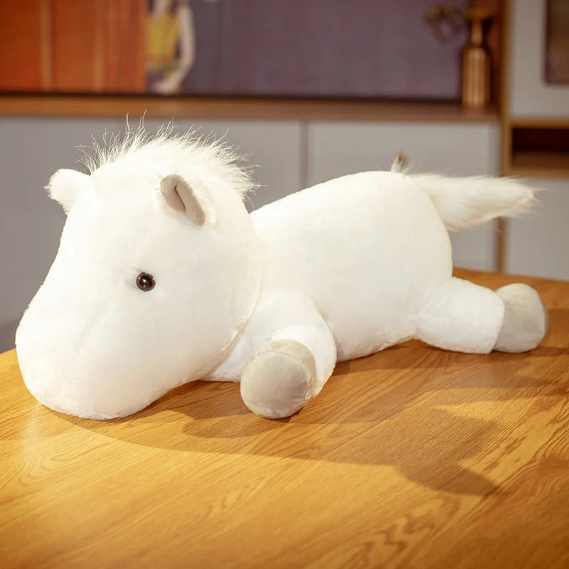 White plush horse toy on a wooden surface with a blurred background