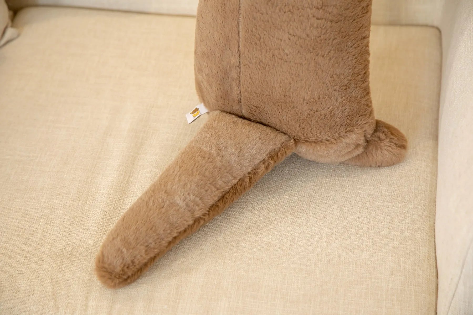 Detailing of a otter soft toy tail on a beige background