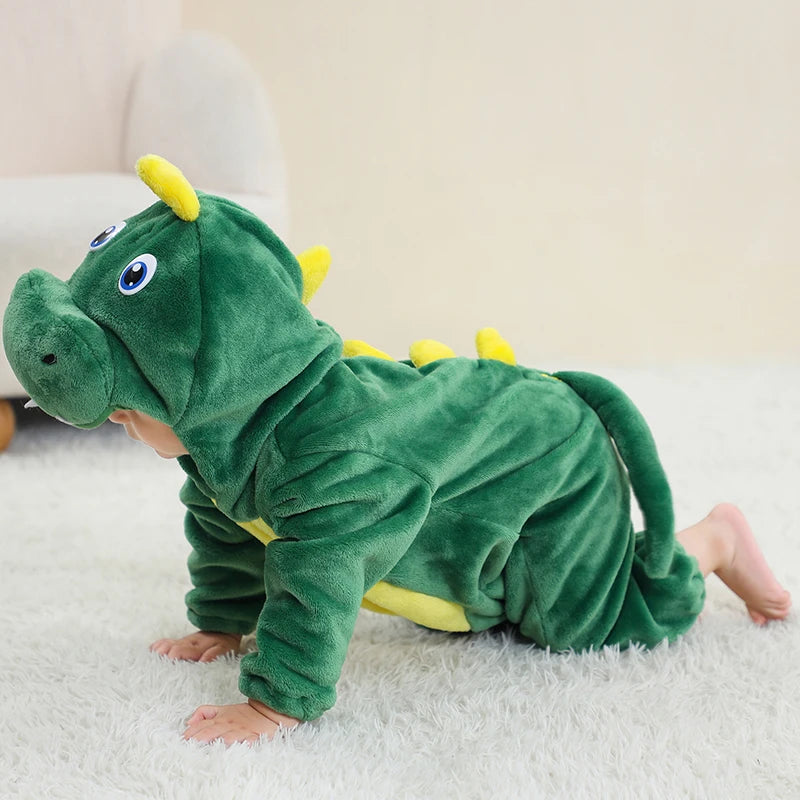 Child wearing a green dinosaur onesie on a light-colored carpet