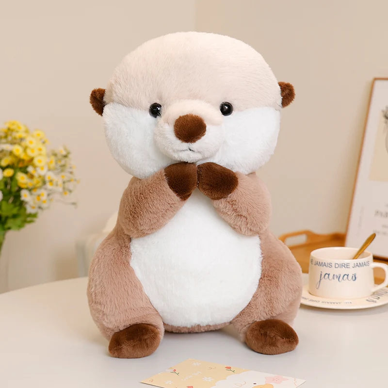 Otter soft toy with a white belly and brown paws, sitting upright on a table with a soft plush finish