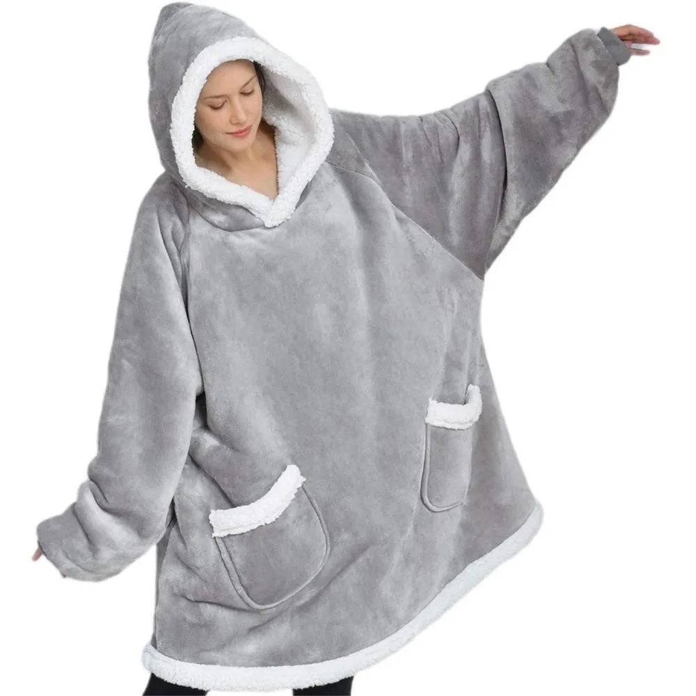 Woman wearing a light grey thick oversized hoodie on a white background.