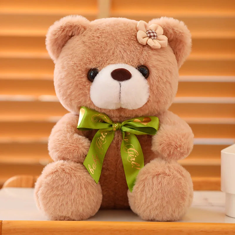 Light brown soft plush teddy bear sitting on a wooden surface