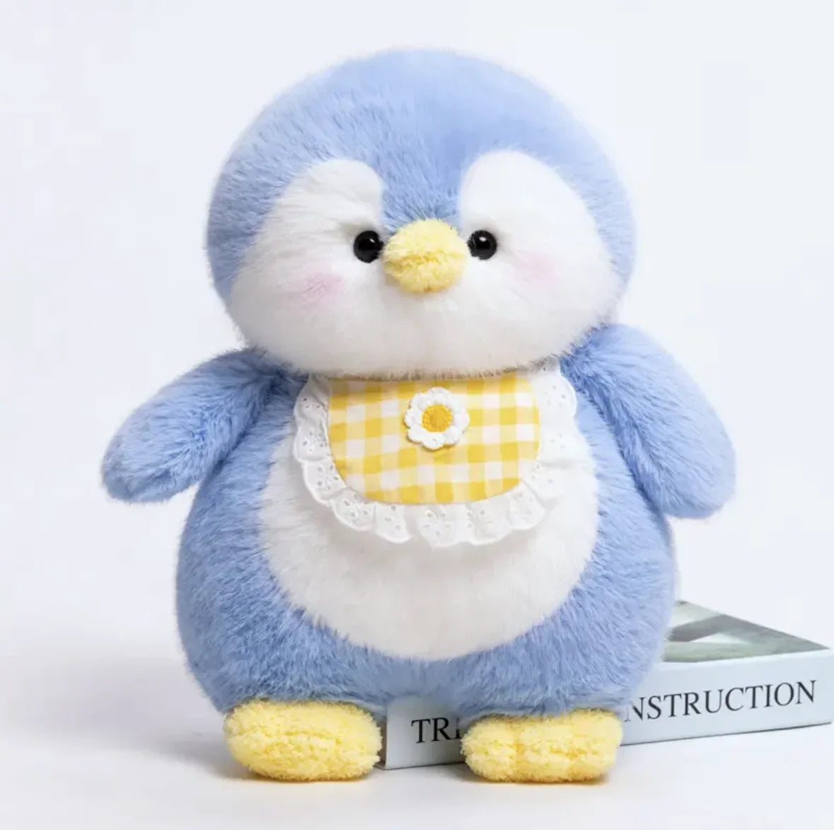 Blue plush penguin with a yellow bib on a white background