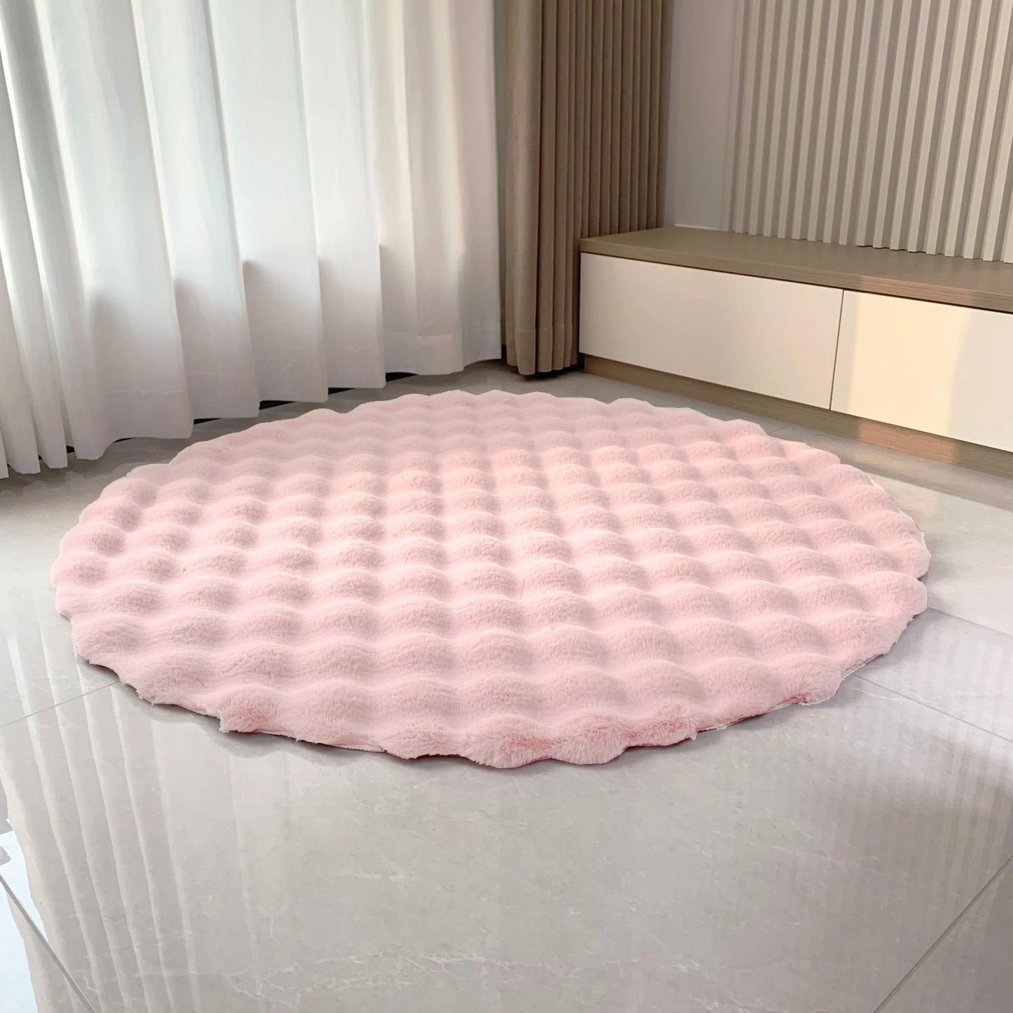 Pale pink round bubble velvet plush rug placed on a light floor by a window