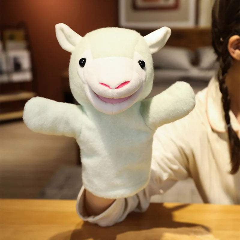 White plush lamb hand puppet held by a person in a blurred indoor setting