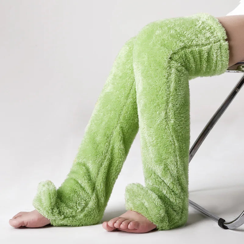 Green fuzzy socks worn by a person on a white background