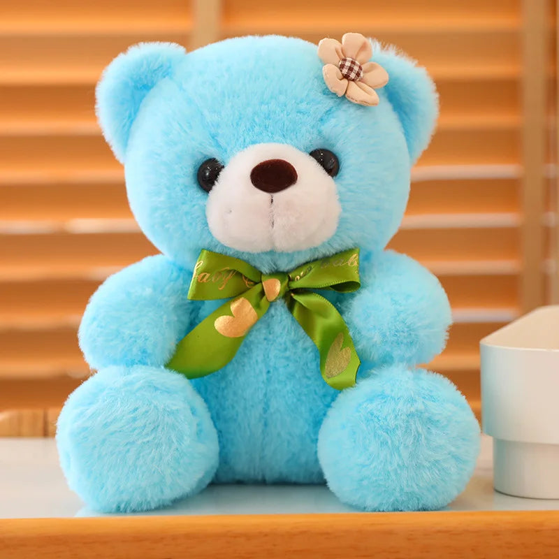 Blue soft plush teddy bear sitting on a wooden surface