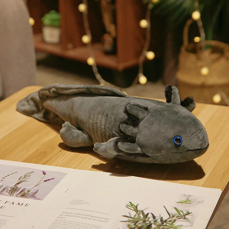 Plush axolotl toy on a table with a magazine underneath