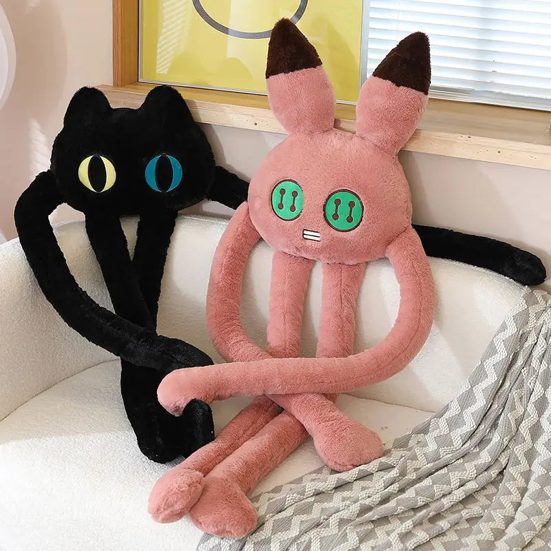 Two plush toys, one black and one pink, sitting on a couch.