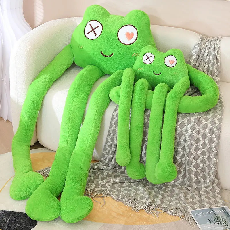 Two green plush toys resembling frogs on a couch.