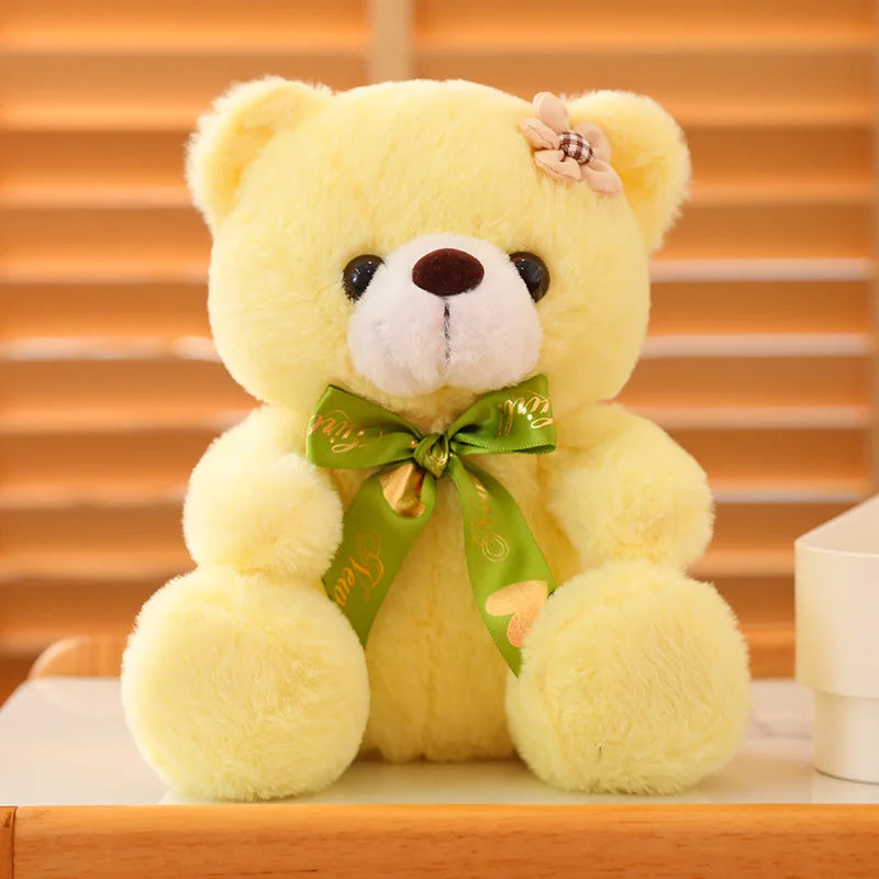 Yellow soft plush teddy bear sitting on a wooden surface