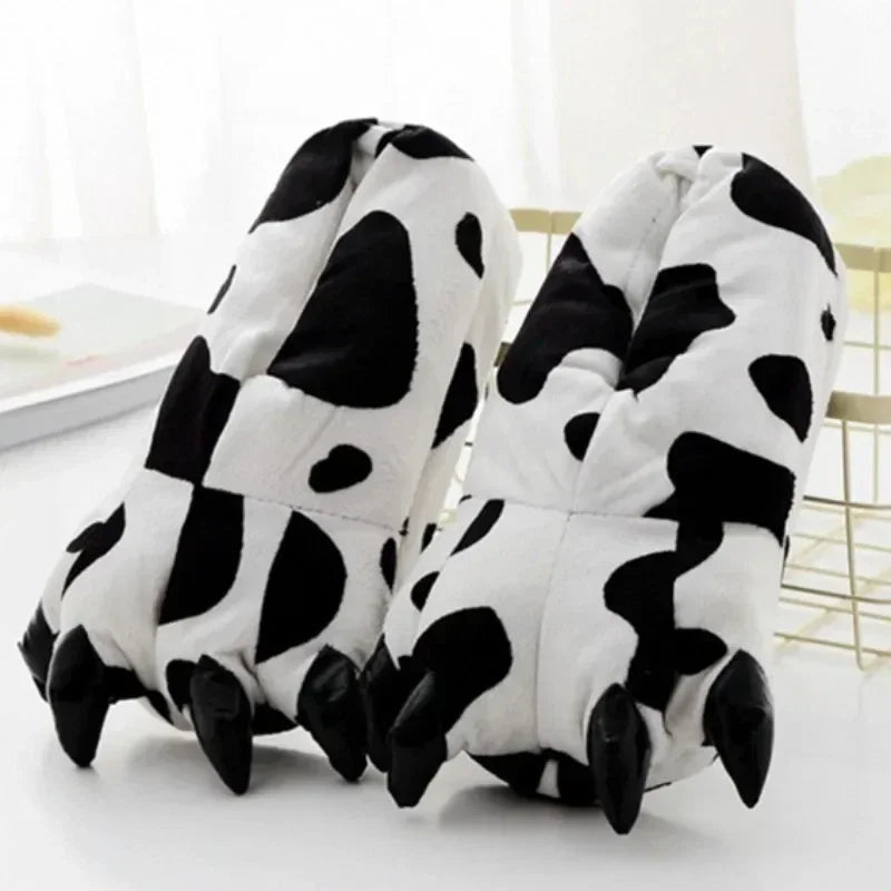 Pair of cow print slippers on a light background