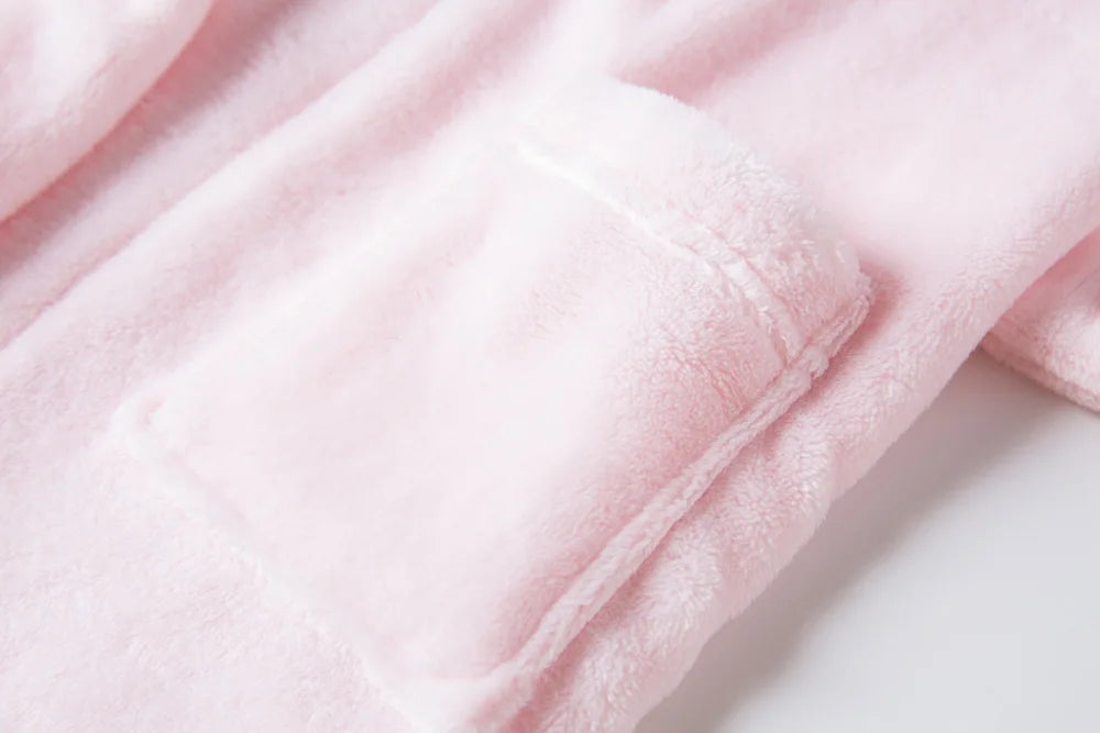 Close up of a pink kid's bath robe's pocket on a white background