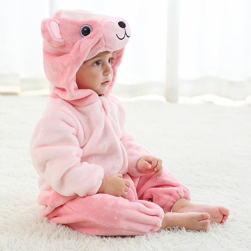 Child wearing a pink bear hooded onesie in a cosy room