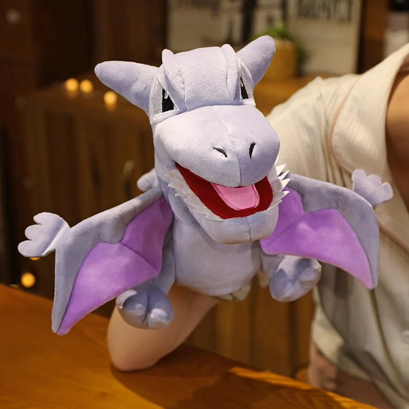 Plush toy resembling pterodactyl with purple accents on a wooden surface.