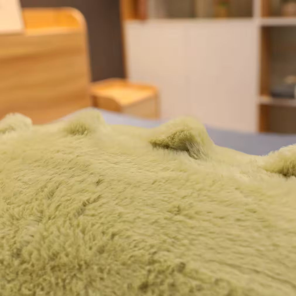 Close up of the spikes on a green soft plush crocodile toy.