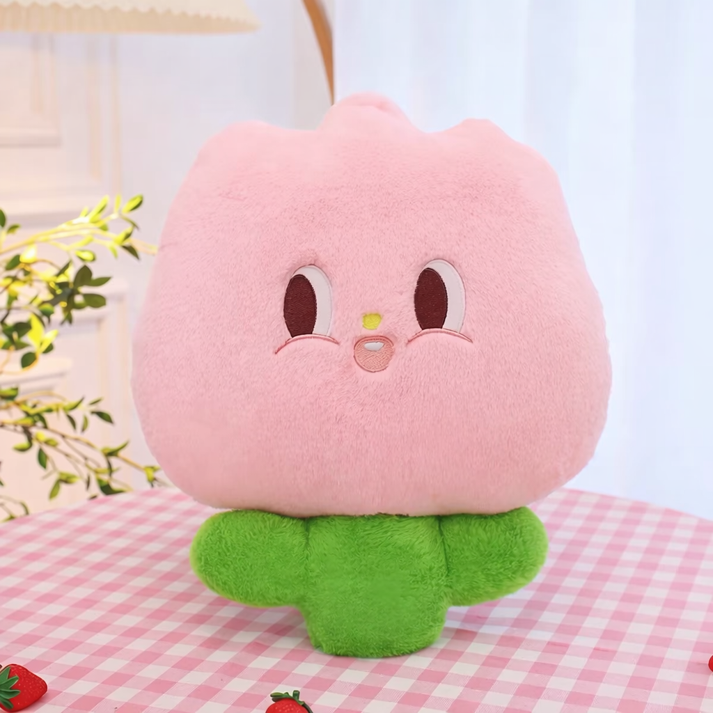 Pink plush soft tulip toy on a table in a comfortable setting.